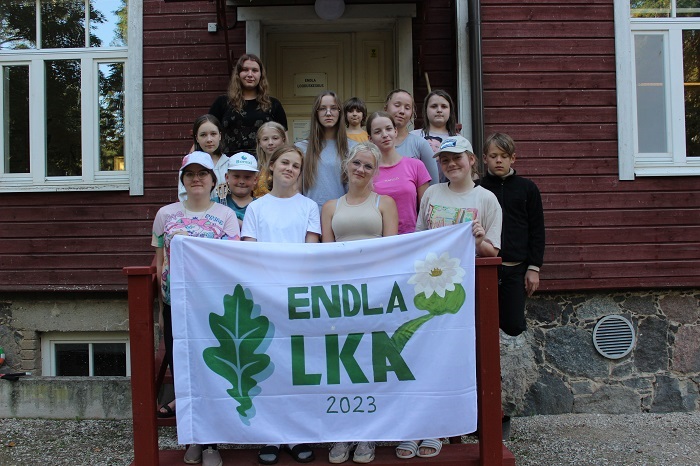 Noored seismas looduskeskuse trepil, käes valge lipp kirjaga Endla LKA 2023