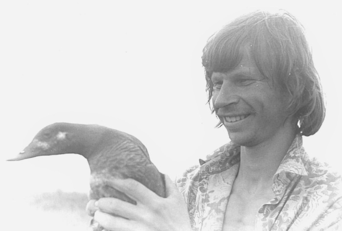 Mees hoidmas naeratades käes lindu
