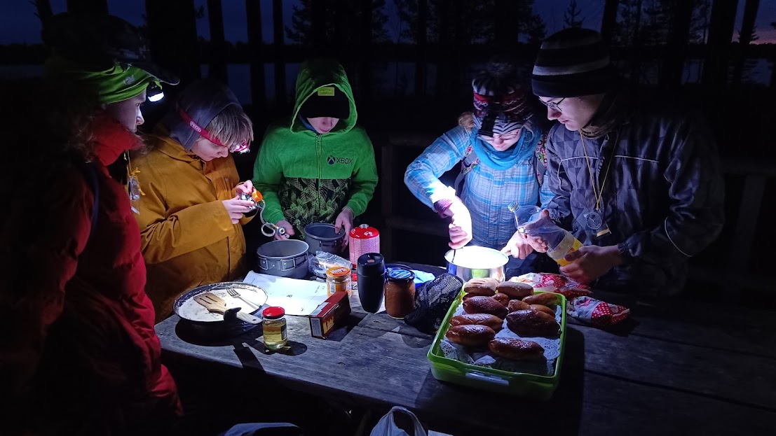 pealampide valgel pimedas metsas õhtusöögi tegemine